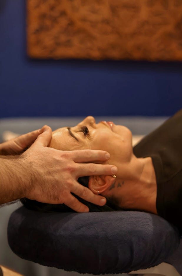 Mathew's hands gently cradling a client's head during Craniosacral Therapy